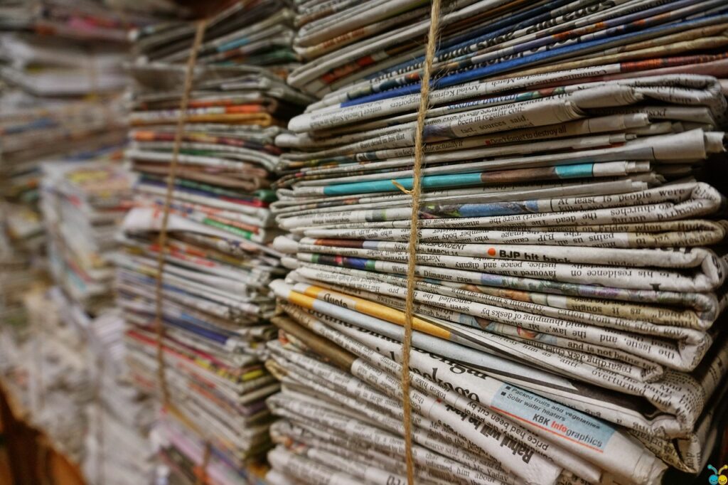 Bundles of newspapers, laid flat in piles and tied together.