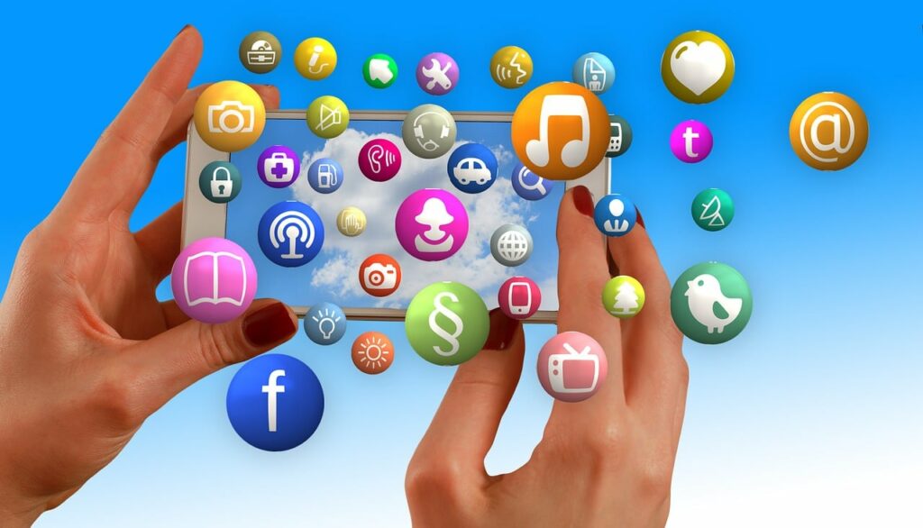 A digital image of hands holding a smartphone with icons of app logos popping out.